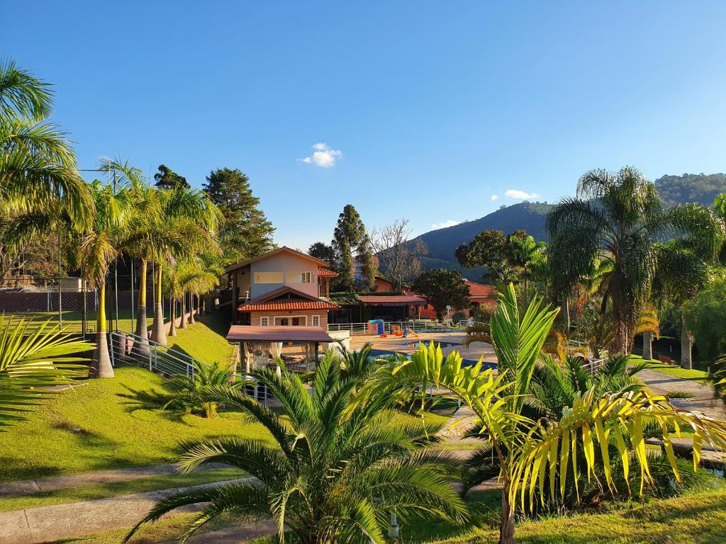a resort with palm trees and a building at Pousada Nefelibatas in Águas de Lindóia