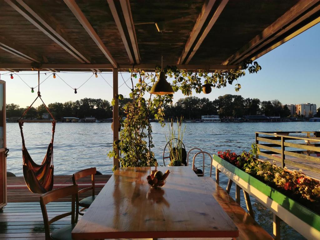 a table and chairs on a dock with the water at En ChillAda River house in Belgrade