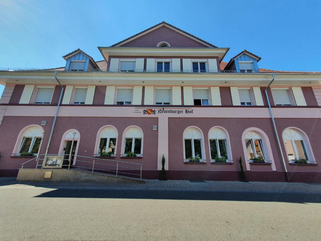 un gran edificio rosa con un cartel en él en Hotel Neuenburger Hof, en Neuenburg am Rhein