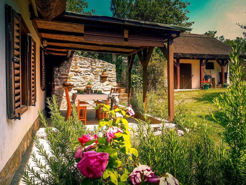 eine Terrasse mit einem Tisch und Blumen vor einem Haus in der Unterkunft Wild Boar Cottage - Romantic getaway in Badacsonytomaj