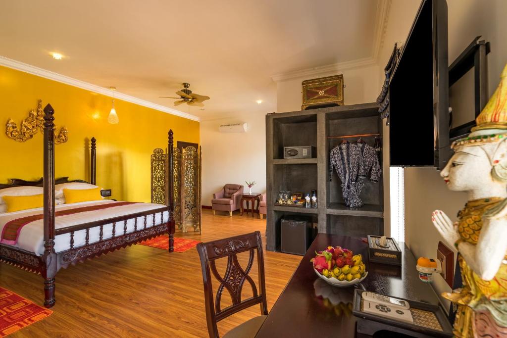 ein Schlafzimmer mit einem Bett und ein Wohnzimmer in der Unterkunft Beyond Yangon Inn in Siem Reap