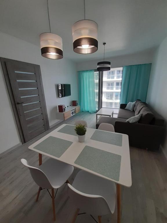 een woonkamer met een tafel en een bank bij Apartament Aniutka in Międzyzdroje