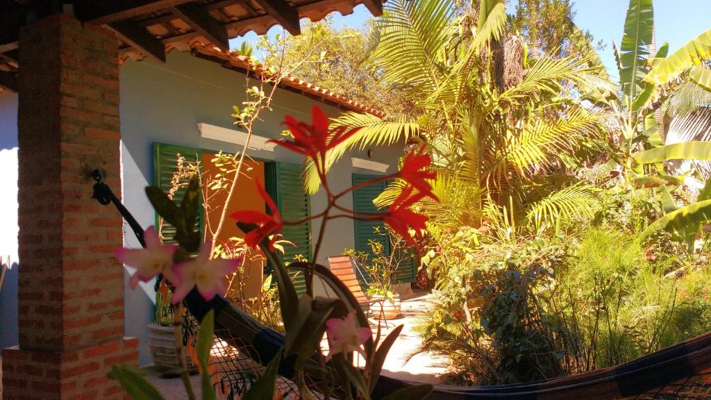 a garden with flowers and plants in front of a house at Suítes Brotas City in Brotas