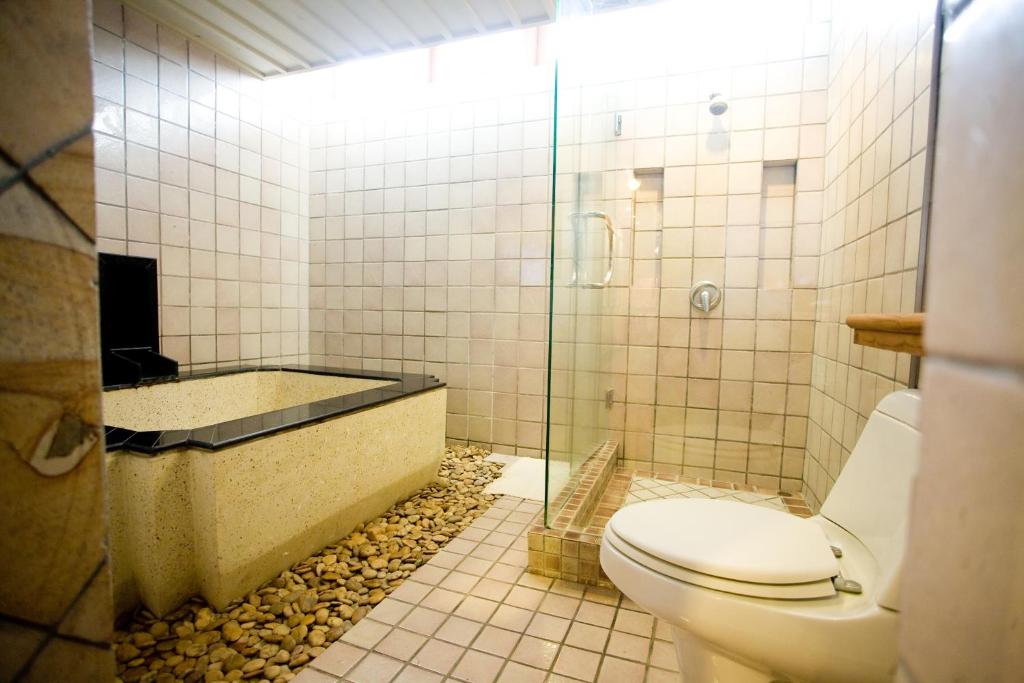 a bathroom with a shower and a toilet and a tub at Montien House - SHA Plus in Chaweng