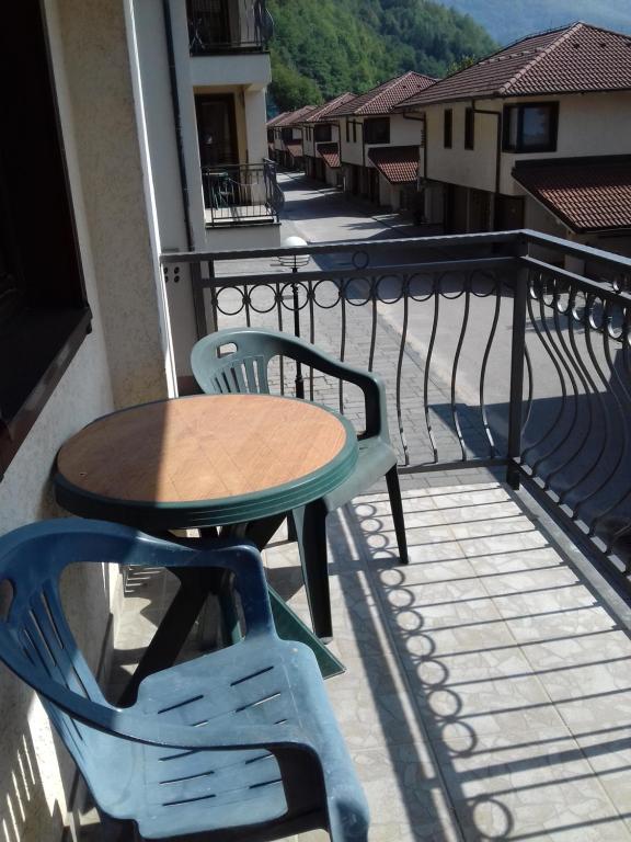 eine Terrasse mit einem Tisch und Stühlen auf dem Balkon in der Unterkunft Street View Apartman in Fojnica