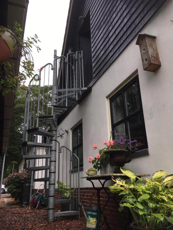 a black and white house with a staircase and flowers at T’ Hogeland Ainrom in Eenrum