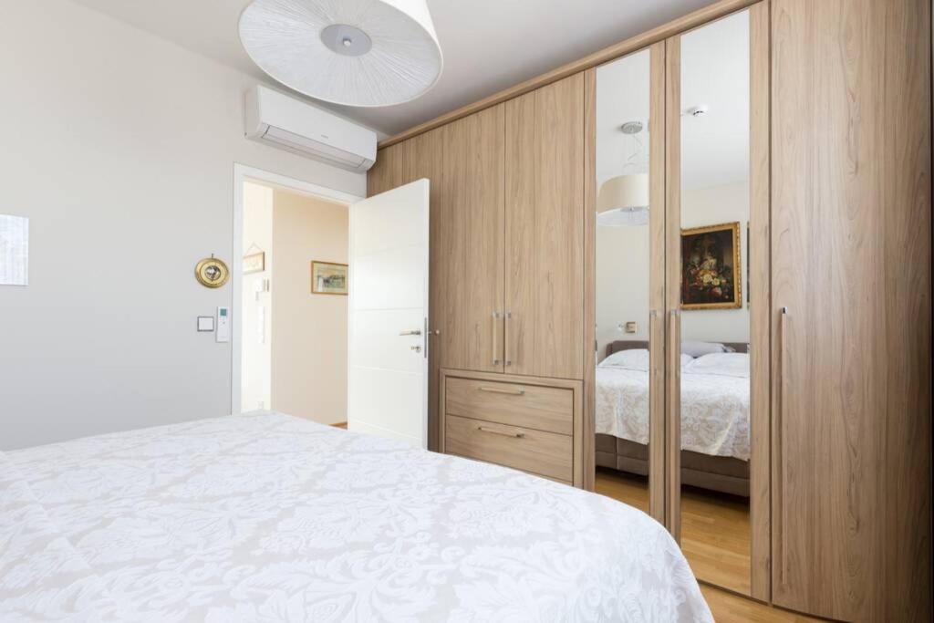 sypialnia z białym łóżkiem i drewnianą szafką w obiekcie Großes Penthouse #12 mit Terrasse und Aussicht w Wiedniu