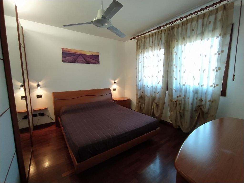una camera con letto e ventilatore a soffitto di Appartamento a Cadoneghe Storica a Cadoneghe