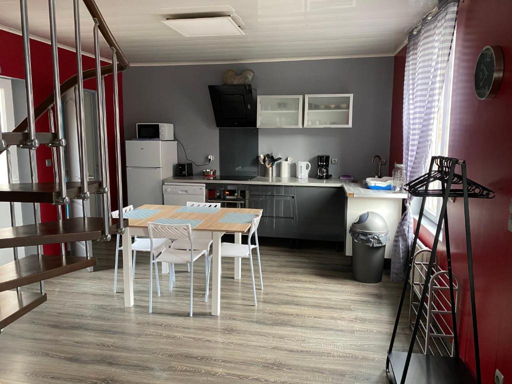 a kitchen with a table and chairs in a room at « Le temps d’un instant » dépendance in Solre-le-Château