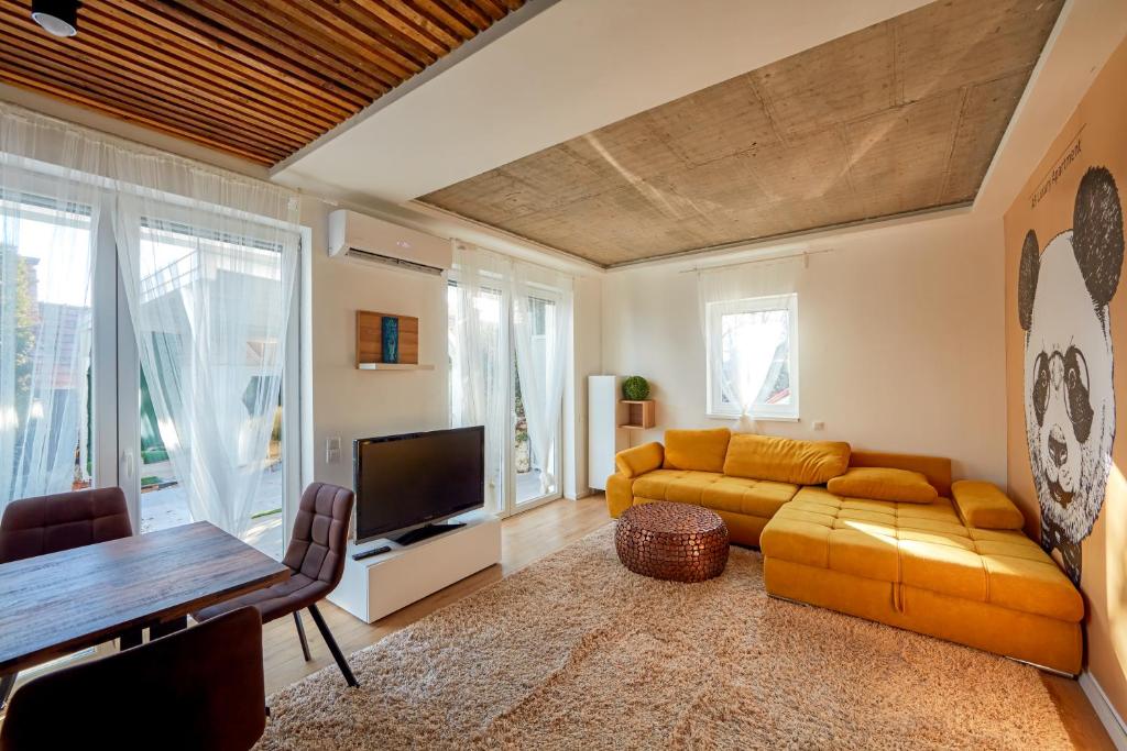 a living room with a couch and a tv at A9 Luxury Balatonudvari in Balatonudvari