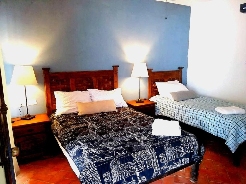 ein Schlafzimmer mit 2 Betten und 2 Lampen an Tischen in der Unterkunft Casa Saltito in San Miguel de Allende