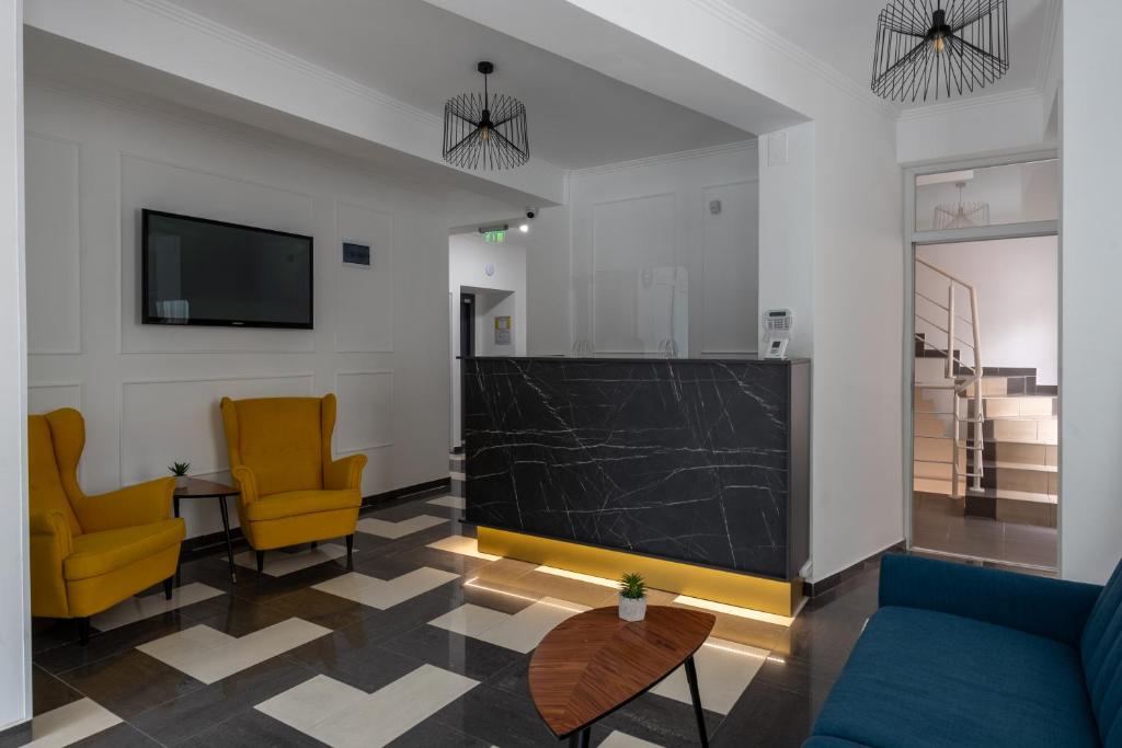 a living room with two chairs and a flat screen tv at Hotel PASO in Cluj-Napoca