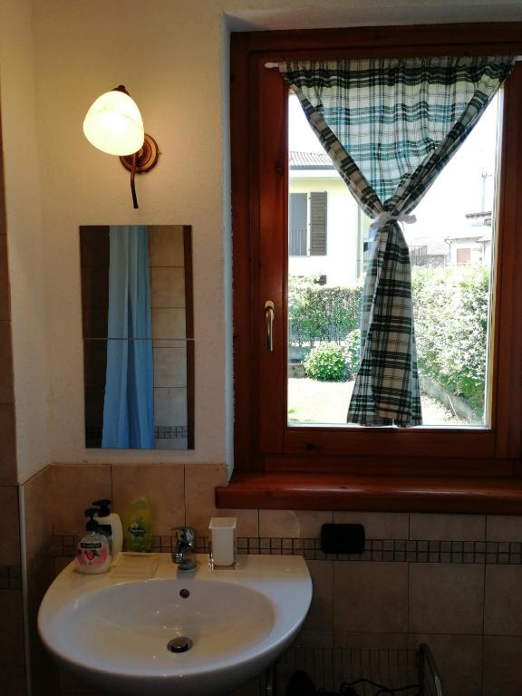 łazienka z umywalką i oknem w obiekcie La casetta di Biancaneve Valtellina e lago di Como w mieście Dubino
