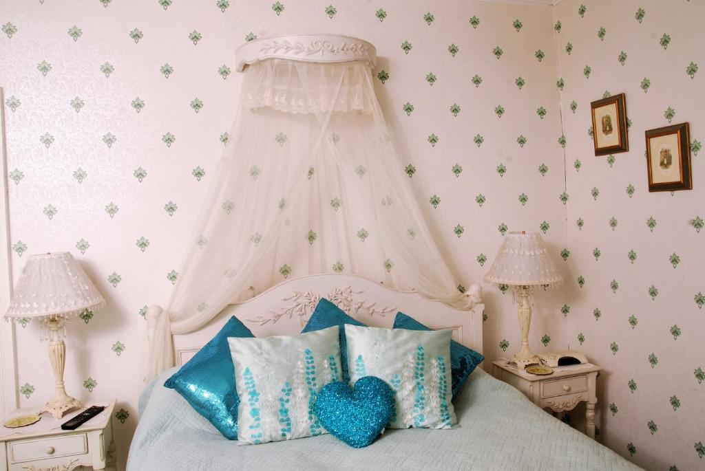 a bedroom with a white bed with blue pillows at Glenart House in Tramore