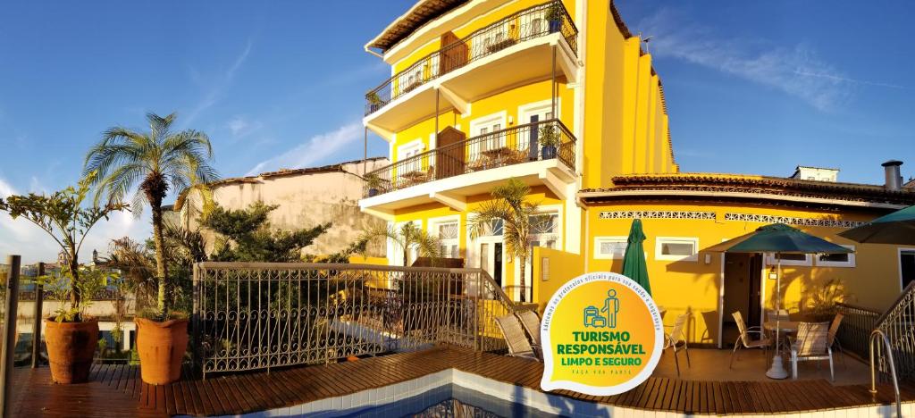 a yellow building with a deck in front of it at Hotel Casa do Amarelindo in Salvador