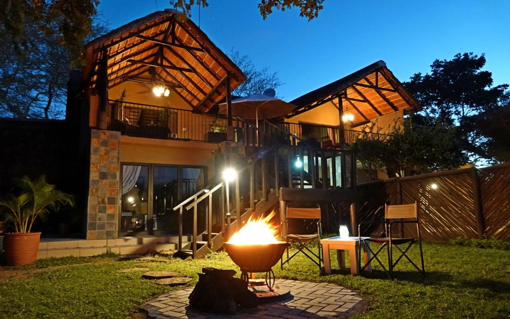 a fire pit in front of a house at night at Tau @ Kruger in Marloth Park