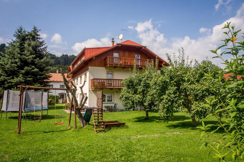 uma casa com um quintal com um baloiço e um parque infantil em Pension Rieger em Radošov
