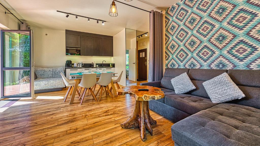 sala de estar con sofá y mesa en Apartament Garden z Sauną Holiday Mountain Residence - 5D Apartamenty, en Świeradów-Zdrój