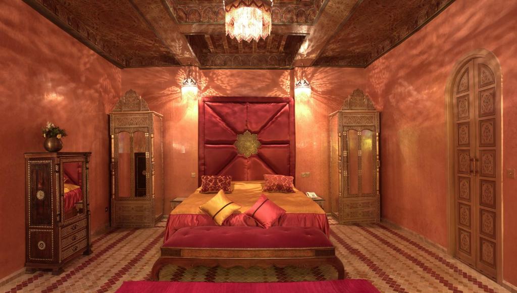 - une chambre avec un grand lit et une tête de lit rouge dans l'établissement Mumtaz Mahal, à Essaouira