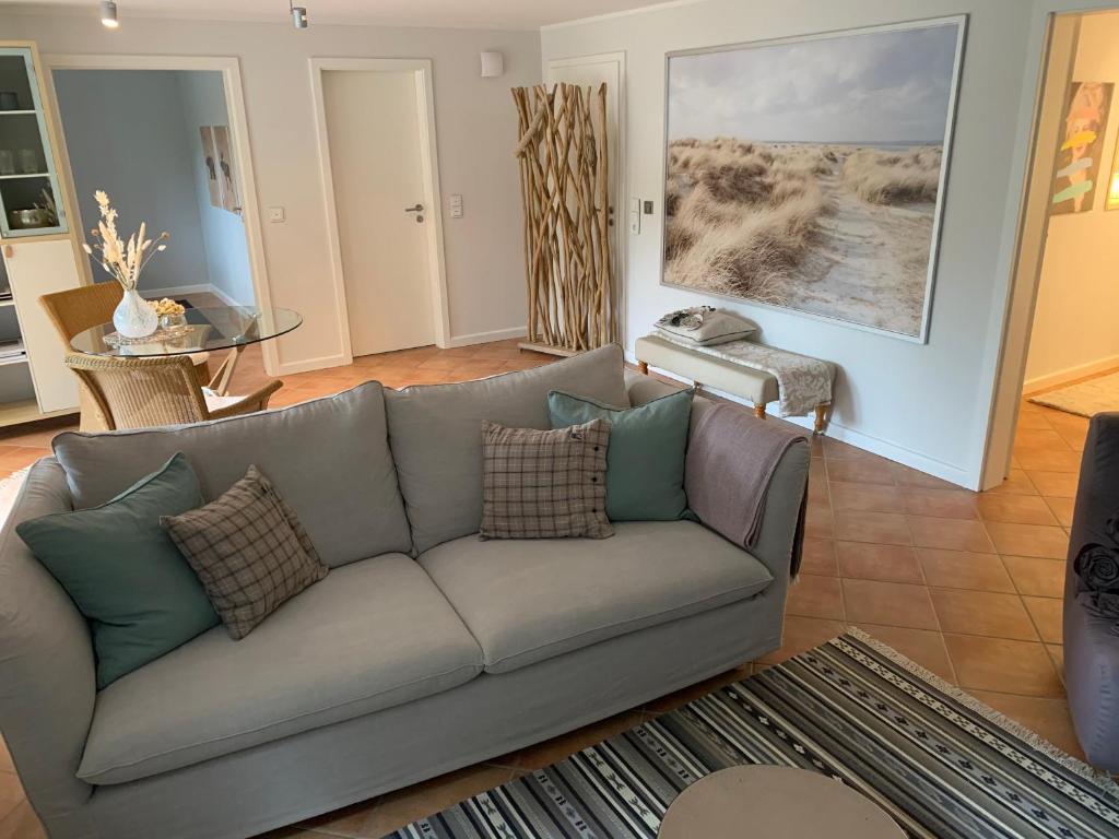 a living room with a gray couch with pillows at Traumhafte Ferienwohnung nahe dem Nord-Ostsee-Kanal in Quarnbek
