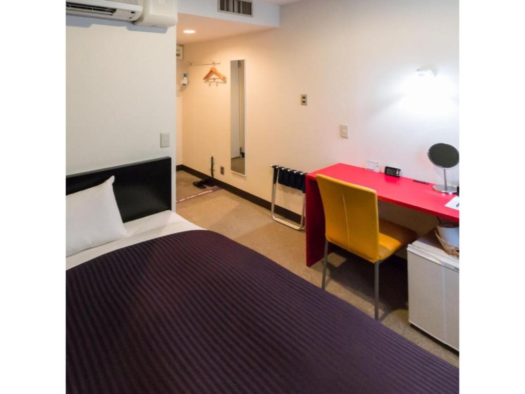 um quarto com uma cama, uma mesa vermelha e cadeiras em Frame Hotel Sapporo - Vacation STAY 92365 em Sapporo