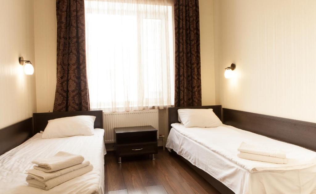 two beds in a room with a window at Solar in Kropyvnytskyi