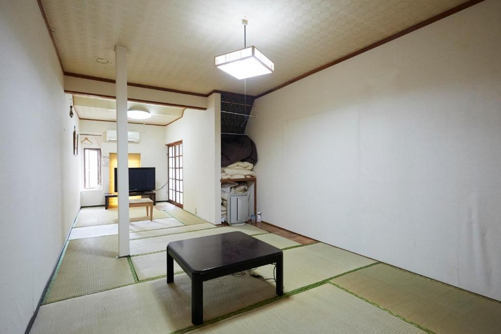 een kamer met een tafel in het midden van een kamer bij Iruka House 1 - Vacation STAY 9266 in Iki