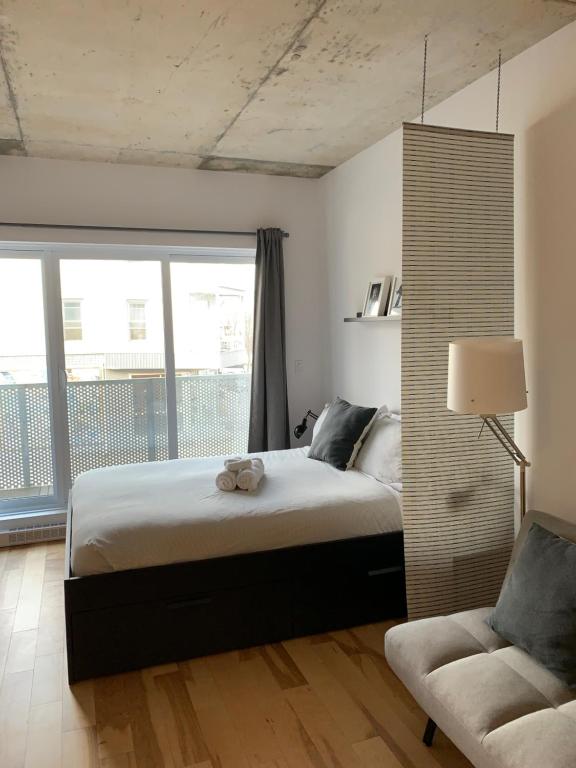 um quarto com uma cama grande e uma cadeira em Le Studio Picasso "parking inclus" em Cidade de Quebec