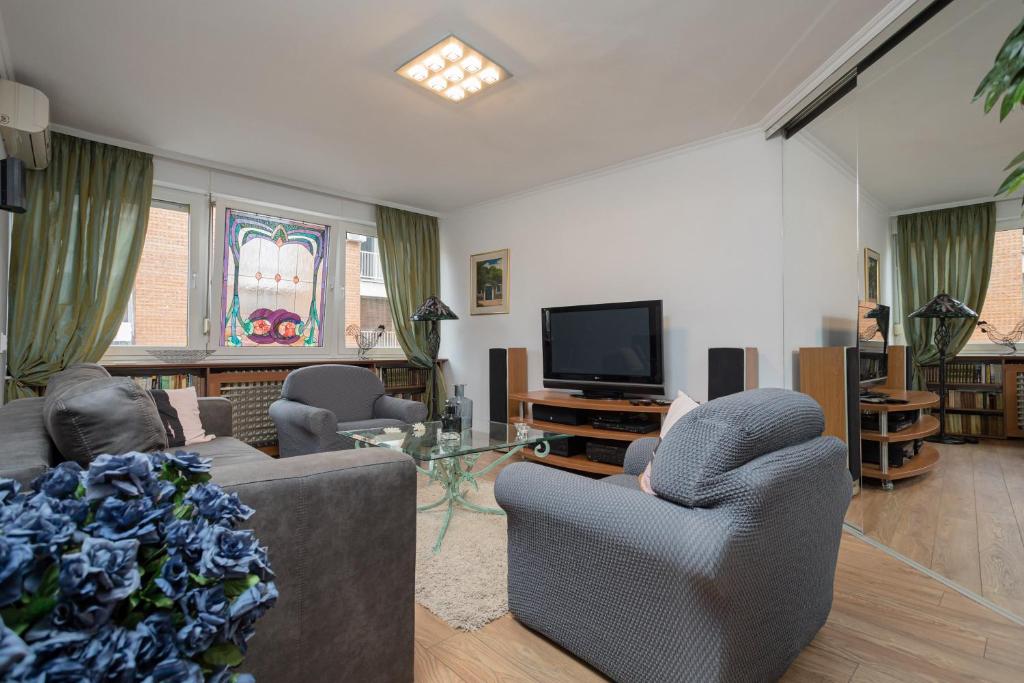- un salon avec deux canapés et une télévision dans l'établissement BelArt apartment, à Belgrade