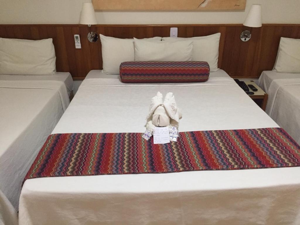 ein Bett mit einem ausgestopften Tier drauf in der Unterkunft Hotel Riviera Lins in Lins