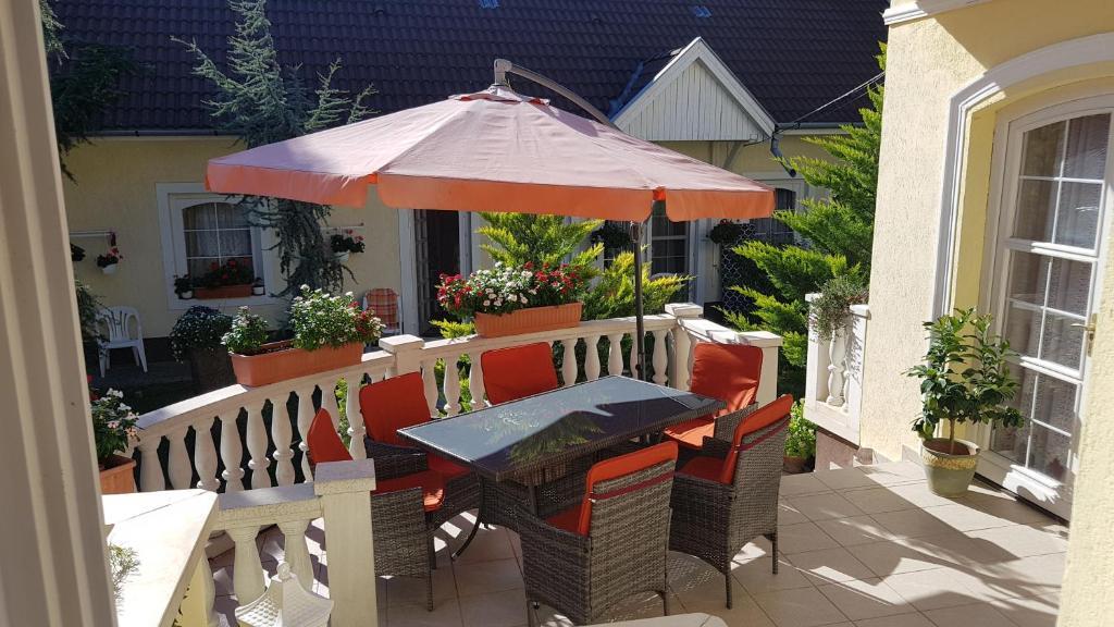 a table and chairs with an umbrella on a patio at Beáta Apartman in Gyula