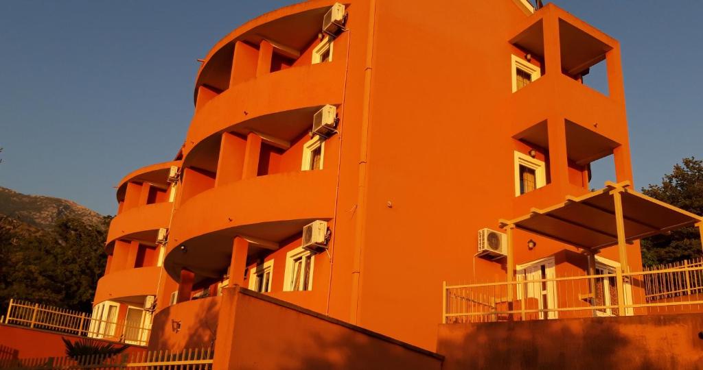 an orange building with balconies on the side of it at Apartments Danilo Kažanegra in Sveti Stefan