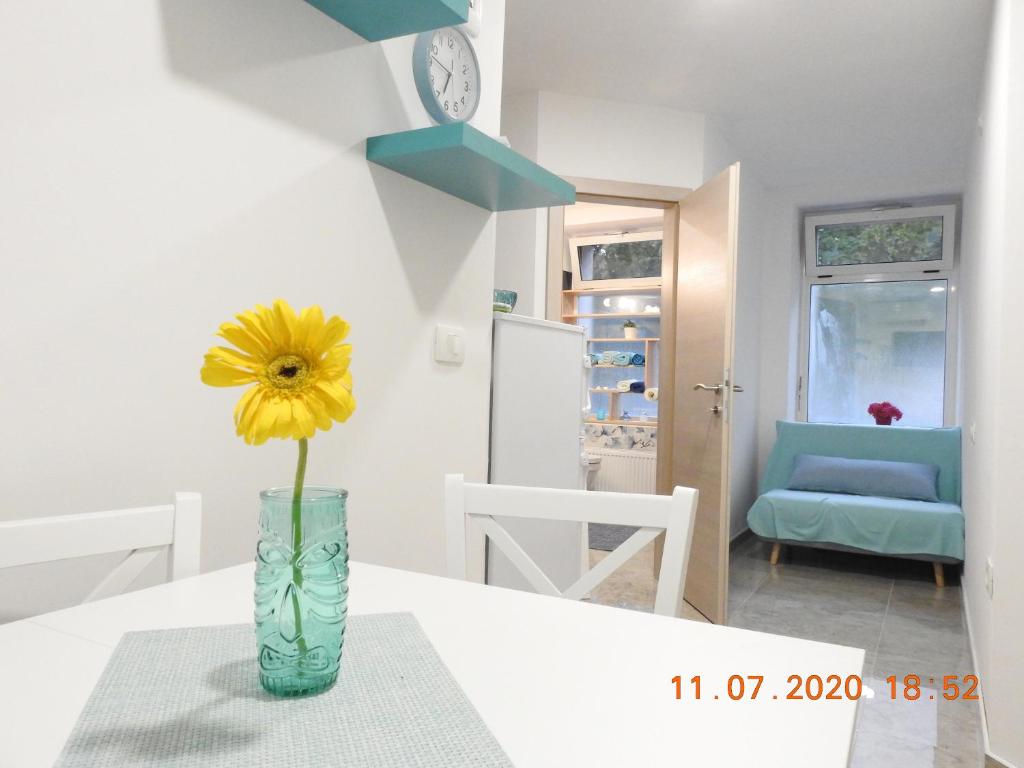 a vase with a yellow flower sitting on a table at Apartma Ada in Tolmin