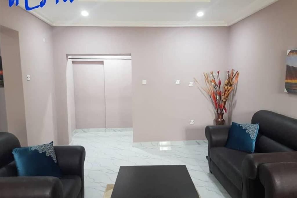 ein Wohnzimmer mit 2 Sofas und einem Tisch in der Unterkunft ULOM 1condos apartment in Owerri
