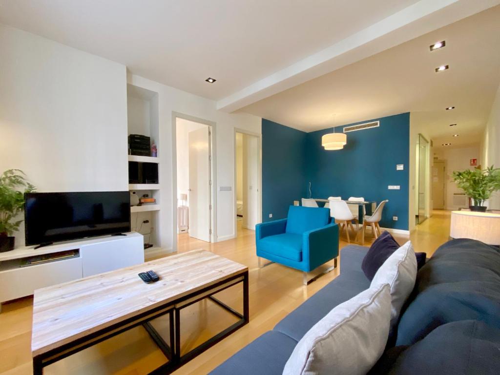 un salon avec un canapé bleu et un fauteuil bleu dans l'établissement Charming Retiro Exclusive, à Madrid