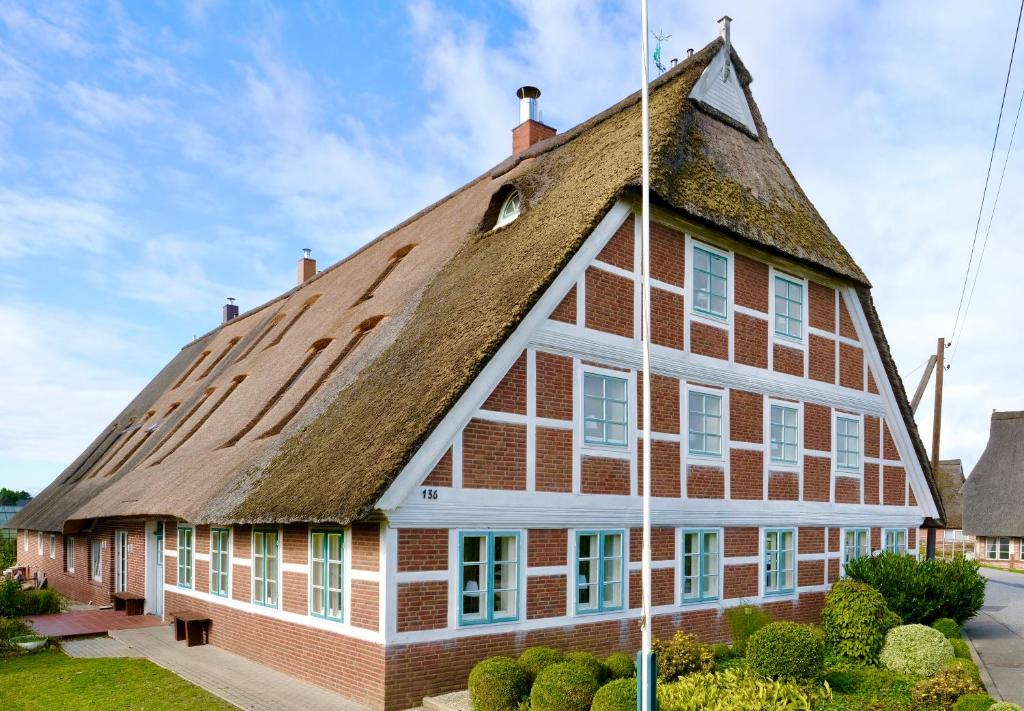 Cette grande maison est dotée d'un toit de chaume. dans l'établissement Hausdeich, à Hambourg