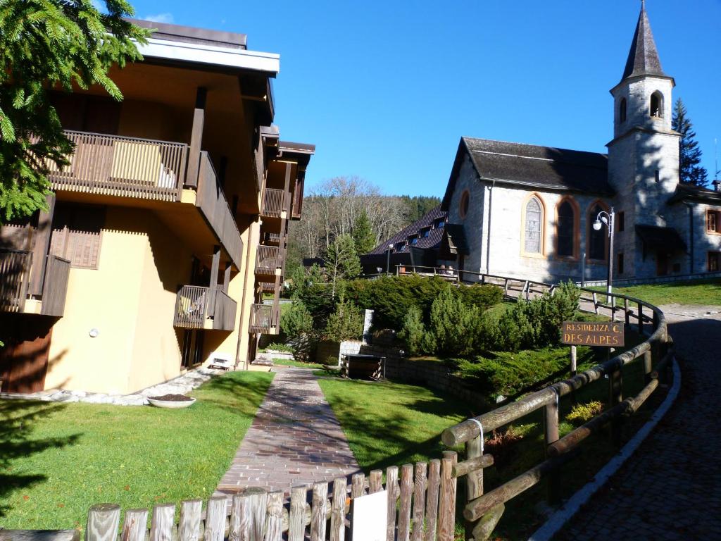 マドンナ・ディ・カンピリオにあるMonolocali Alberti - Des Alpesの教会と建物の隣の木製の柵
