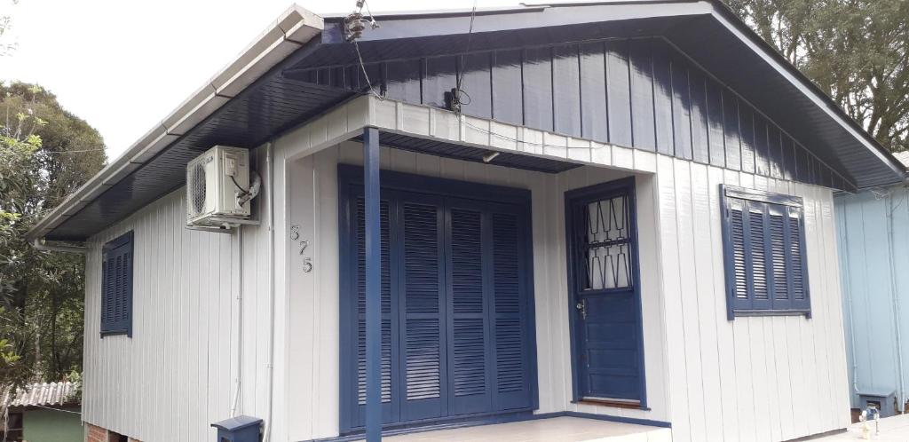 une petite maison avec une porte bleue sur elle dans l'établissement Casa do Joaquim, à Bento Gonçalves