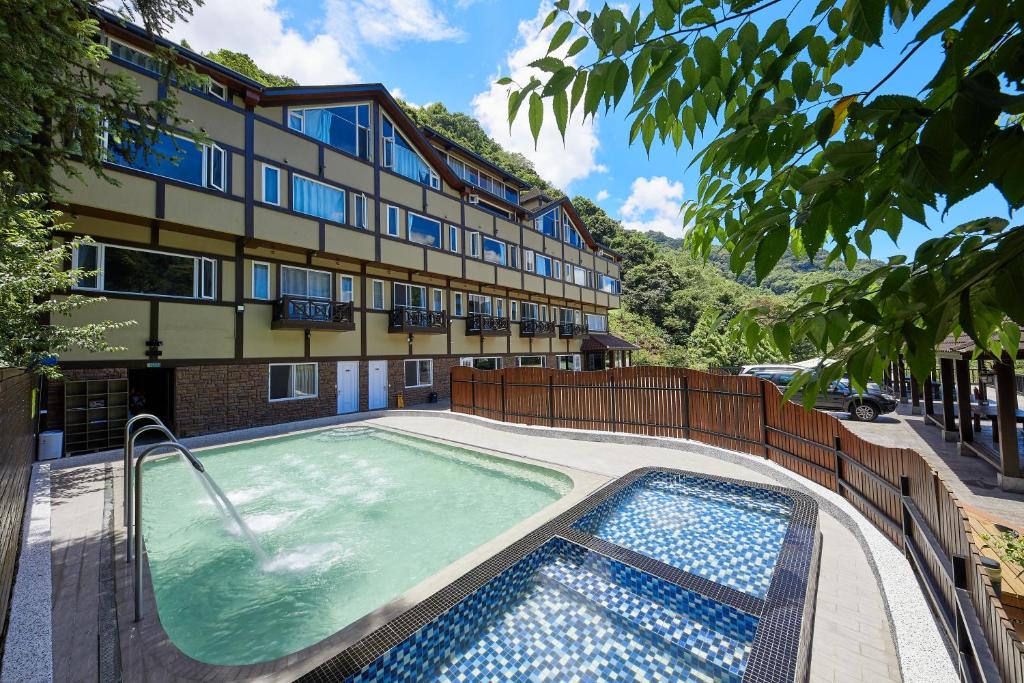 un hôtel avec une piscine en face d'un bâtiment dans l'établissement Yun Xiang Villa 未接待12歲以下孩童, à Renai