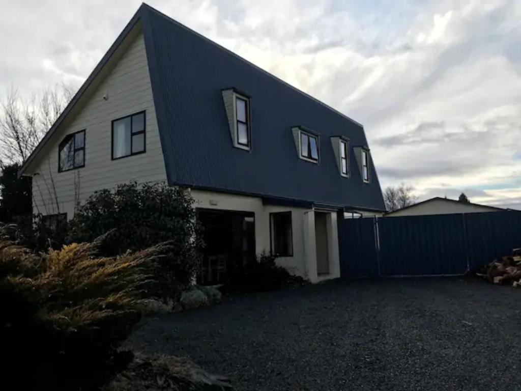 a house with a blue roof and a garage at Arches on Bendrose in Twizel