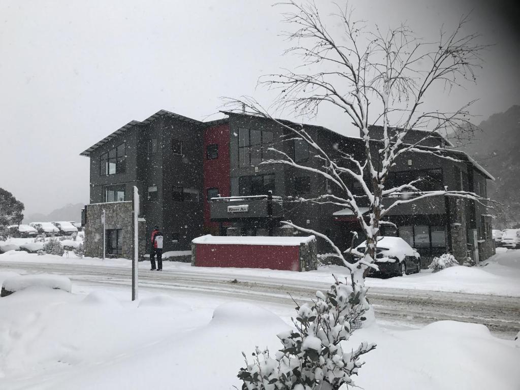 a person standing in the snow in front of a building at Blues Air 3 in Thredbo