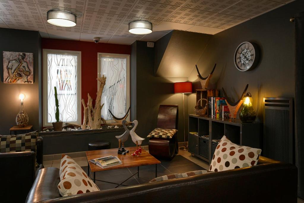 ein Wohnzimmer mit einem Sofa und einem Tisch in der Unterkunft Le Pardaillan in Gondrin