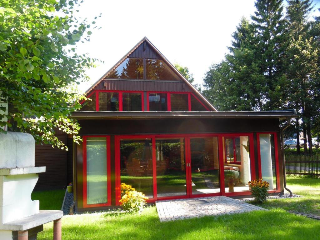 ein Haus mit roten Türen auf einem Hof in der Unterkunft Ferienwohnung Haus Waldeck in Neuhermsdorf