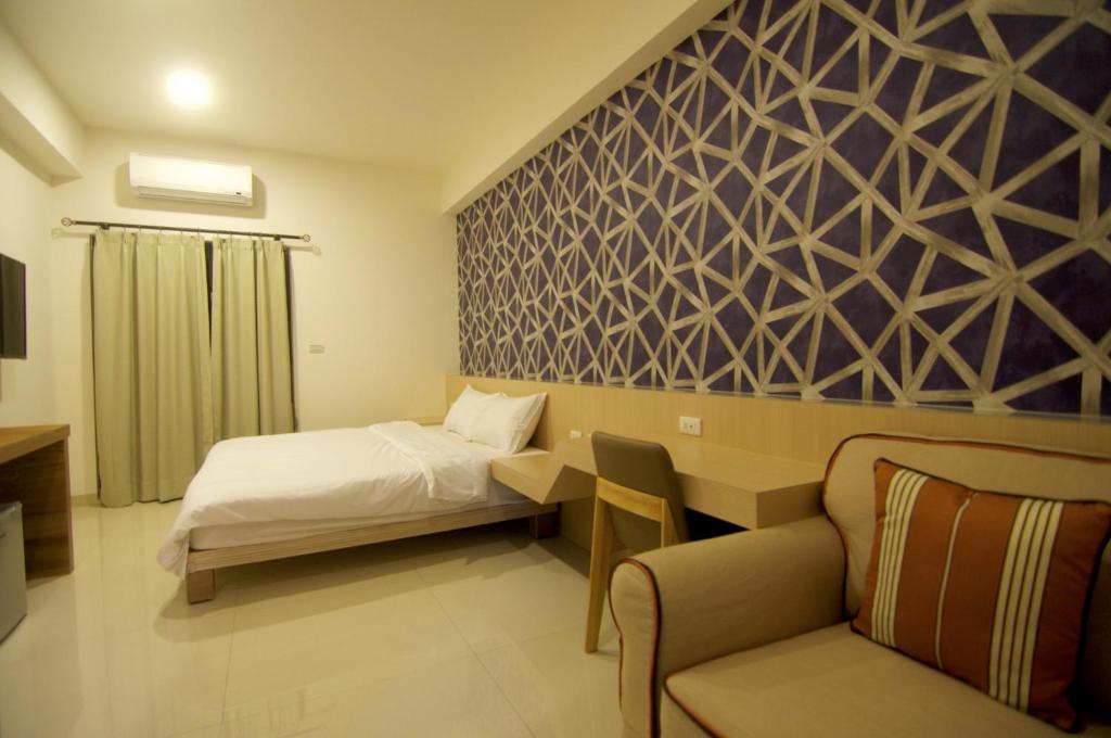 Habitación de hotel con cama y silla en Ai's Inn en Magong