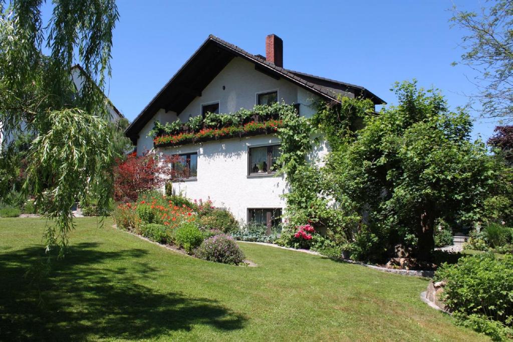 慕斯巴赫的住宿－Ferienwohnung Schieder，白色房子的一侧有鲜花