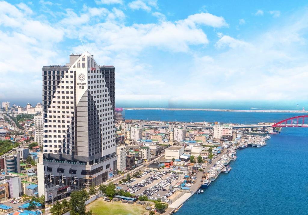 a tall building with a clock tower next to the water at Sea Cruise Hotel in Sokcho