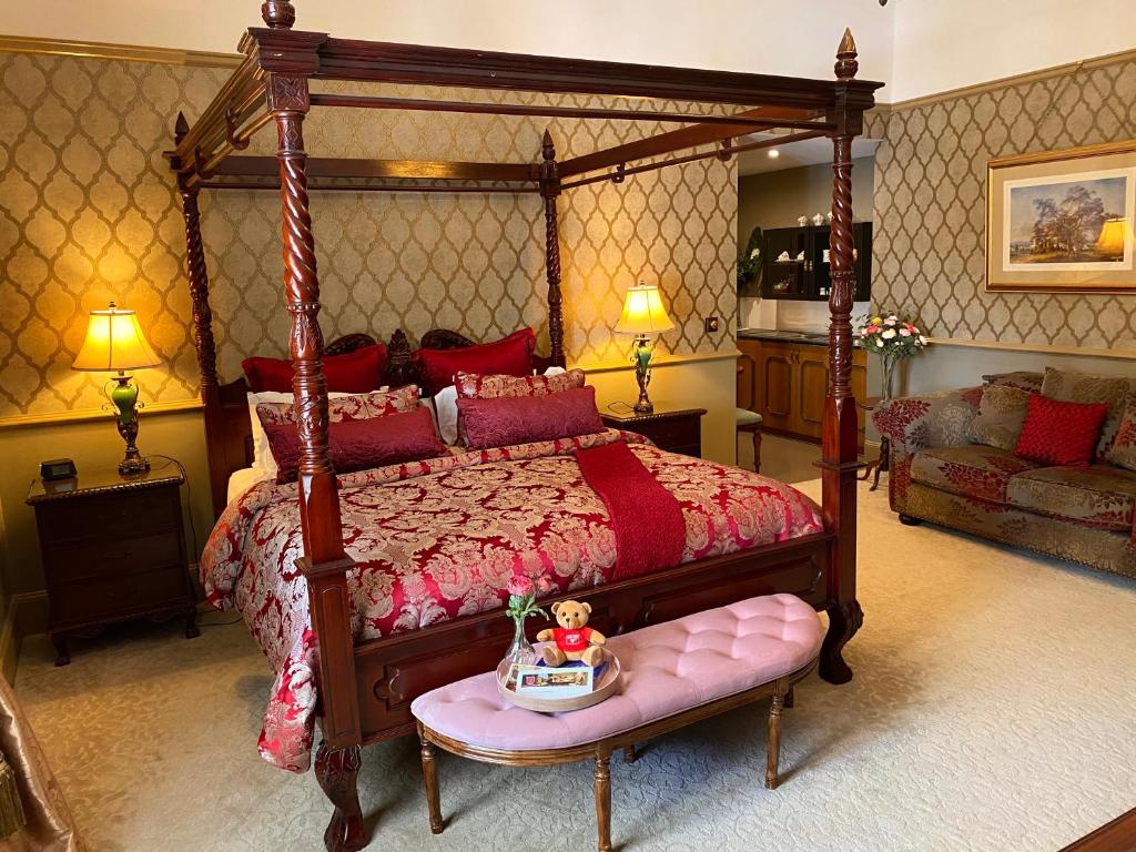 a bedroom with a canopy bed with a doll sitting on a bench at Bli Bli House Riverside Retreat in Twin Waters