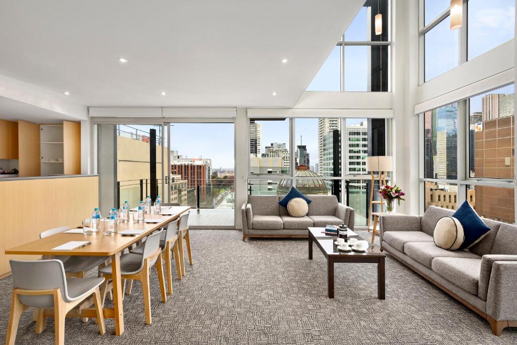 a living room with a table and chairs at Quest on William in Melbourne