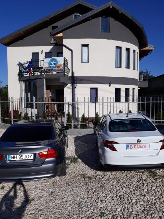 dos autos estacionados frente a una casa en ROMSIL CASA VACANTA, en Costinesti