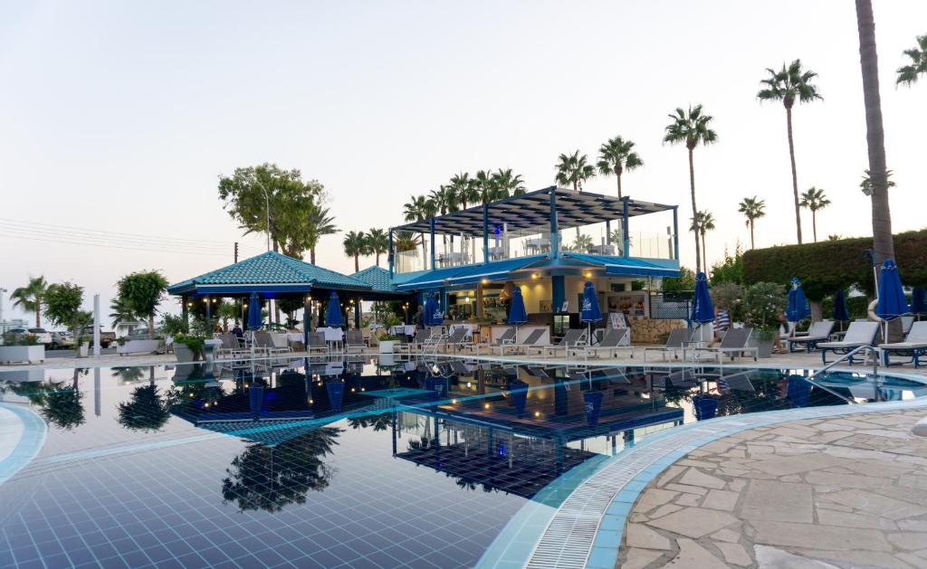 a pool at a resort with chairs and a building at Anonymous Beach Hotel (Adults 16+) in Ayia Napa